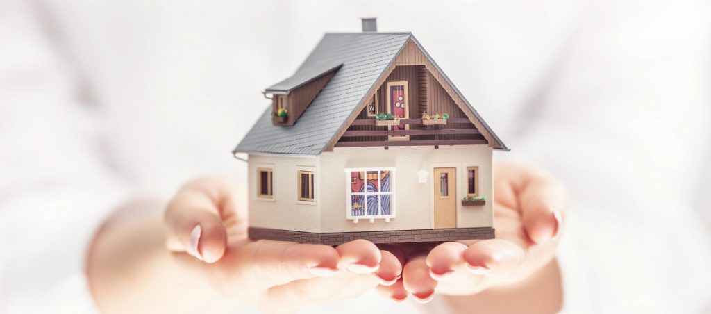 手のひらに乗る住宅模型。柏での土地購入や不動産投資に関心のある方へ向けた、安心感と価値を伝えるイメージ。