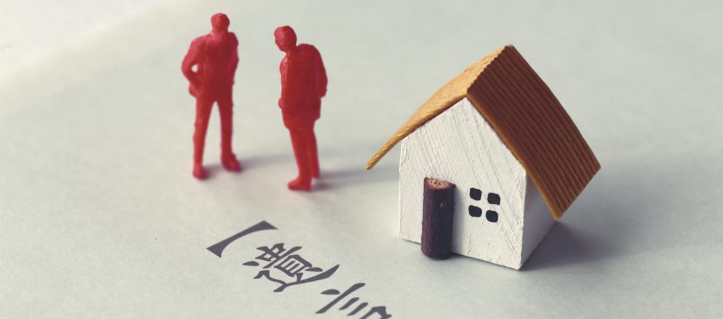 柏市の相続不動産売却におけるトラブルを象徴する家と相続人の模型。遺産分割協議や相続問題を視覚的に表現。