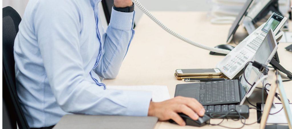 1 柏の管理会社で賃貸物件の電話対応とPC業務を行う担当者の様子