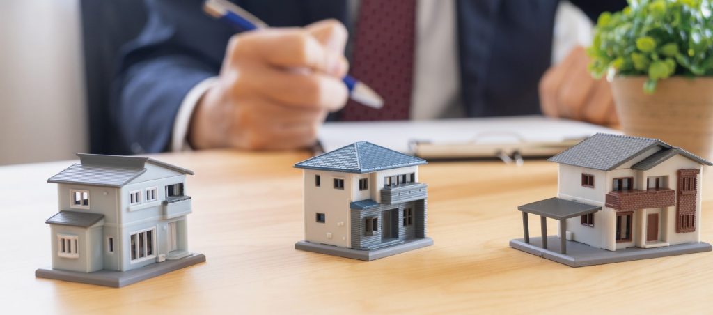 柏市の賃貸管理会社変更のタイミングを説明するイメージ。複数の住宅模型が並び、手続きを検討する様子