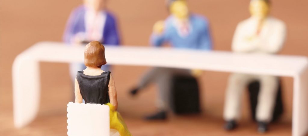 面接会場を模したミニチュア模型で、面接官の前に座る女性の姿が描かれている。柏市の不動産管理会社での面接をイメージした一場面。