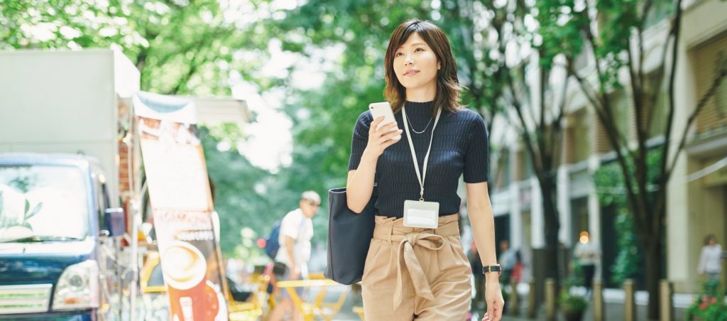 柏の管理会社への転職を考える女性が、街中で不動産業界のキャリアを模索している様子。