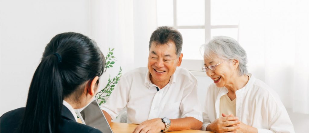 不動産売却の費用やスケジュールを相談する笑顔のご夫婦と担当者