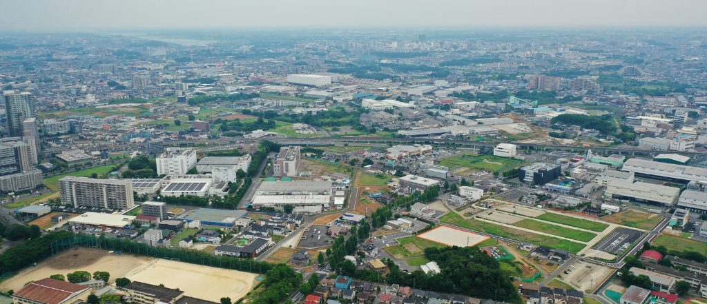 柏駅周辺の俯瞰写真。商業施設や学校が立ち並び、再開発が進む柏エリアの主要駅と住宅街の様子がわかる空撮。住みやすさと利便性を兼ね備えた柏の街並み。