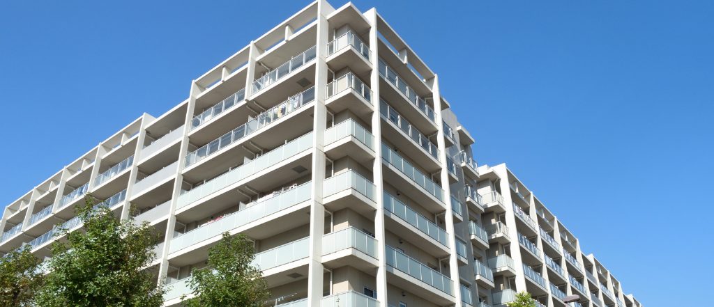 青空の下に建つ大型マンション外観。我孫子市の不動産売買市場における人気の分譲マンションイメージ。