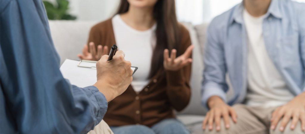 リノベーションについて相談する若い夫婦と担当者。暮らしから考えるリノベーションの打ち合わせイメージ。