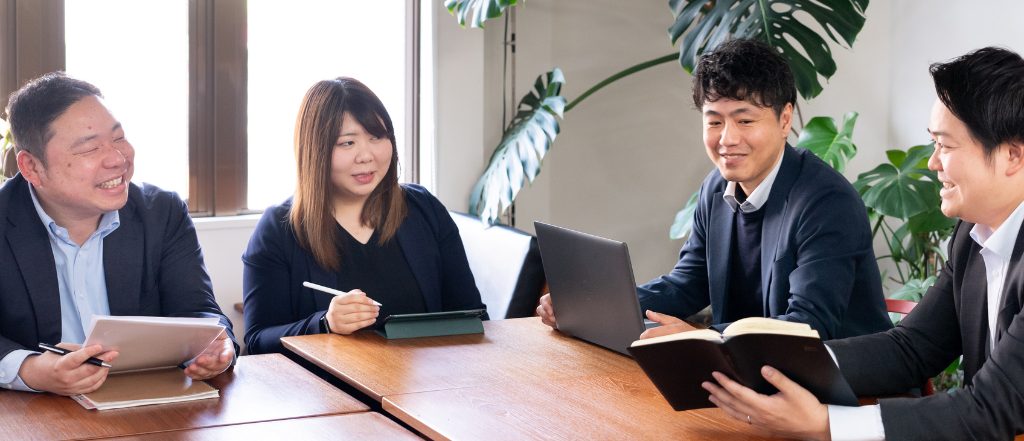 会議をする不動産会社スタッフの写真。我孫子市で地域密着の不動産会社・晃南土地が住まい探しをサポートする様子。