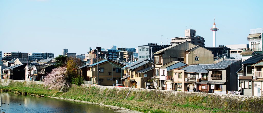 我孫子市の水辺に並ぶ住宅街と、街並みの上空に広がる青空。我孫子の住みやすい街並みと不動産を象徴するイメージ。