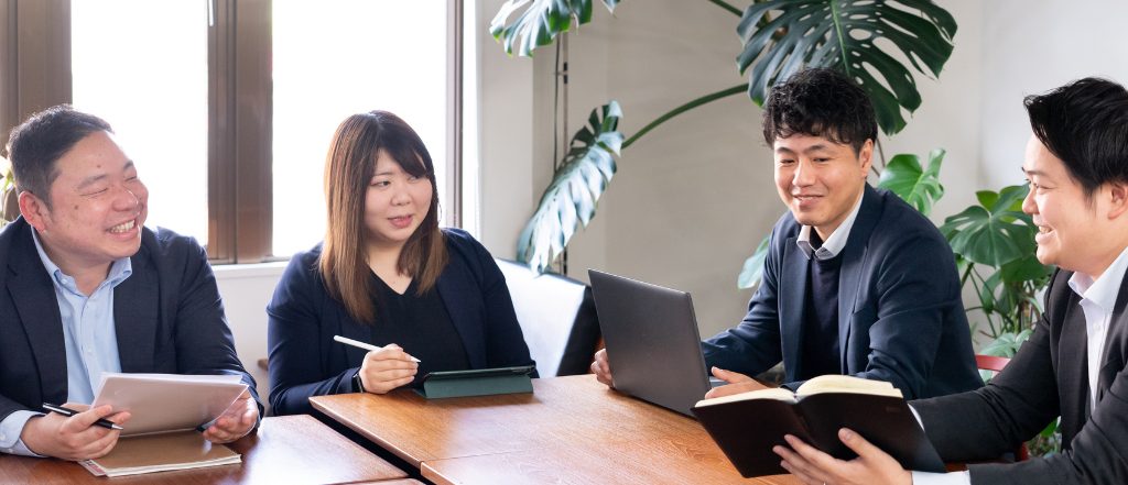 相談相手として、不動産会社の売買スタッフが笑顔で談笑している様子。