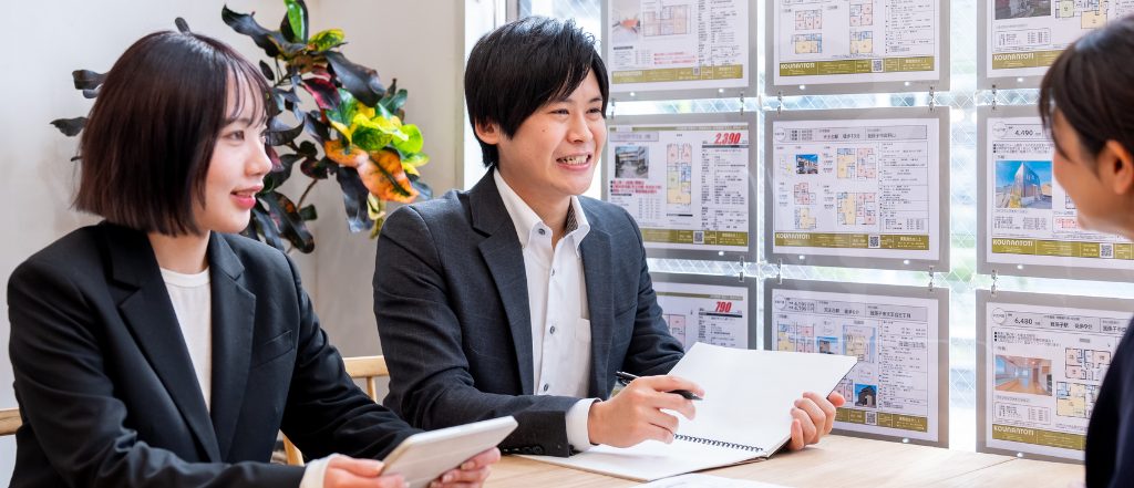 晃南土地不動産のスタッフが笑顔で対応している様子の写真。実際の晃南土地での撮影カットを使用している。
